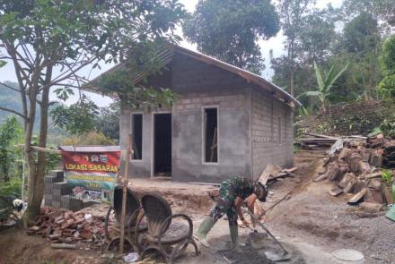 Pak TNI Mengaduk Semen Untuk Bangun Rumah Ibu Sainem