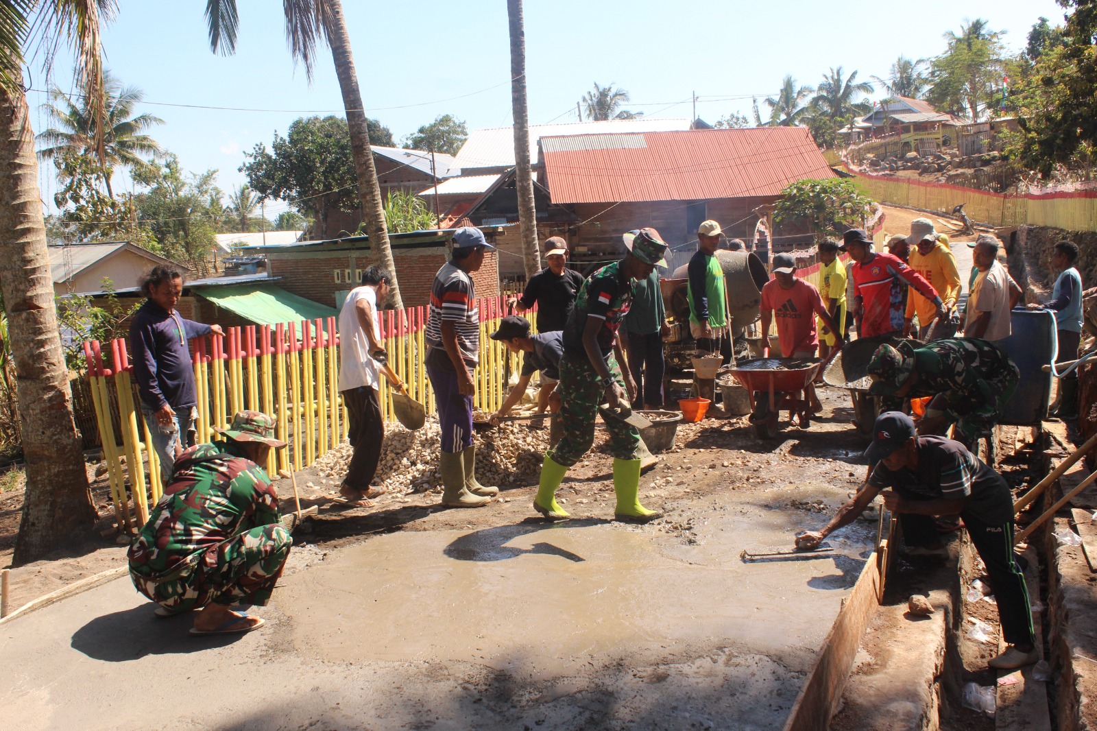 ( Gotongroyong Satgas TMMD deangan Warga Desa Ria Mau Saat Pengecoran Jalan )